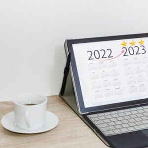 Coffee cup with business goal list on digital tablet and calendar